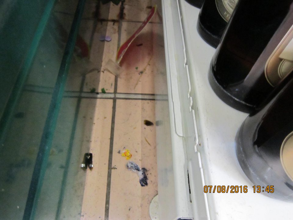 V prevádzke znečistená podlaha, zvyškami obalových materiálov a črepinami z rozbitých fliaš.