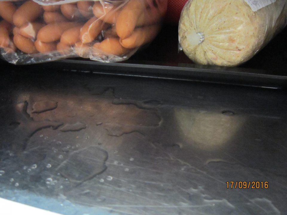 V podpultí chladiaceho pultu nahromadený stekajúci kondenz.  