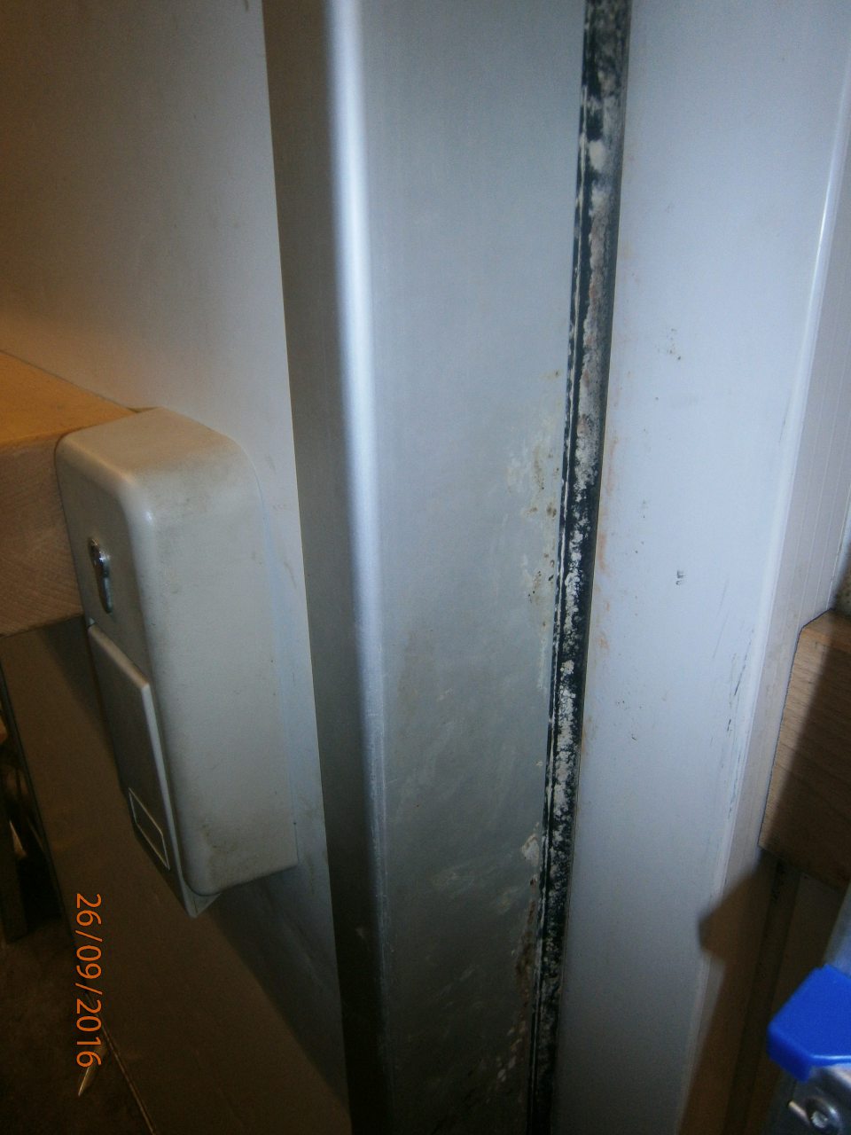 V mraziarenskom sklade predajne korózia a znečistený rám dverí s výskytom plesne.
