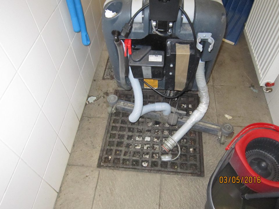 Znečistená podlaha a kanalizačná vpusť v upratovacej miestnosti.