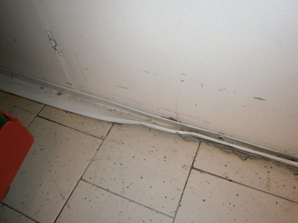 V chladiarni mäsa, hydiny, údenín a mopra poškodená obvodová lišta a znečistená podlaha.