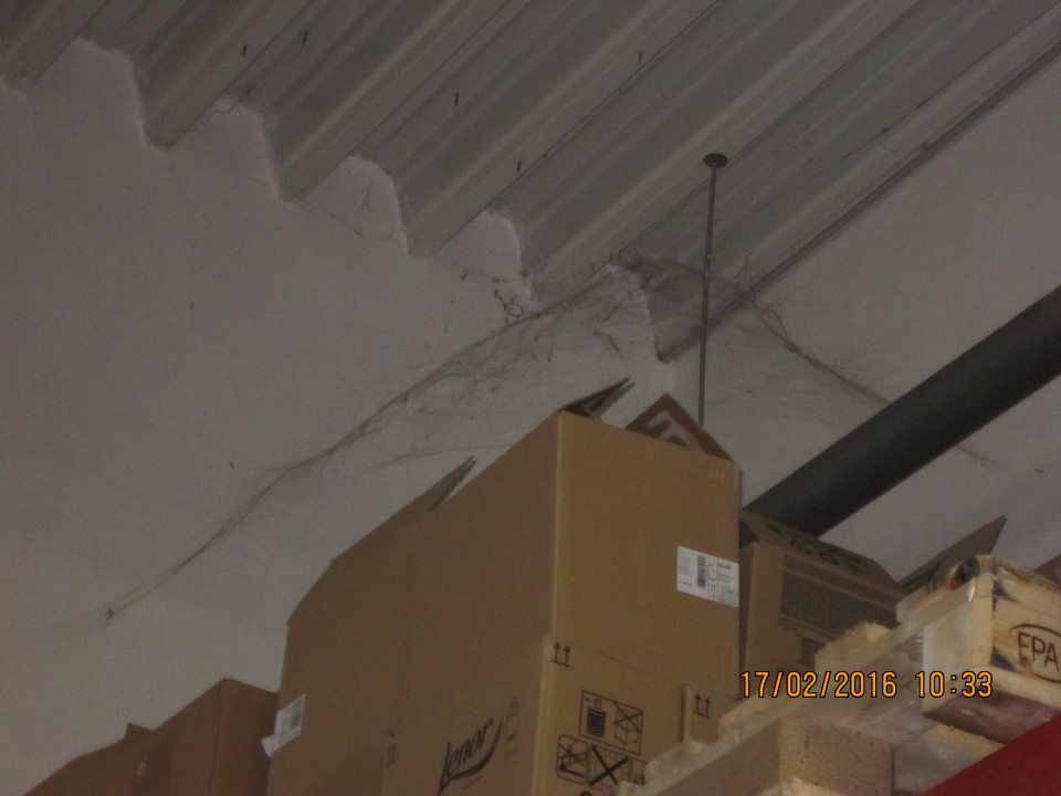 Výskyt pavučín v sklade nad regálmi.