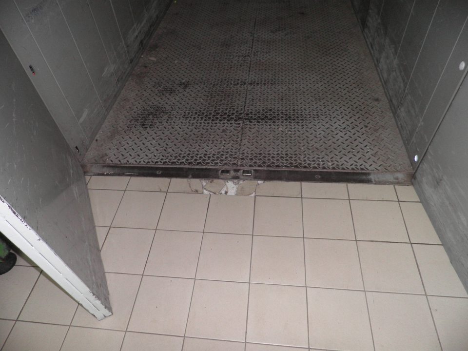 Poškodená dlažba na podlahe v manipulačnom priestore prevádzky