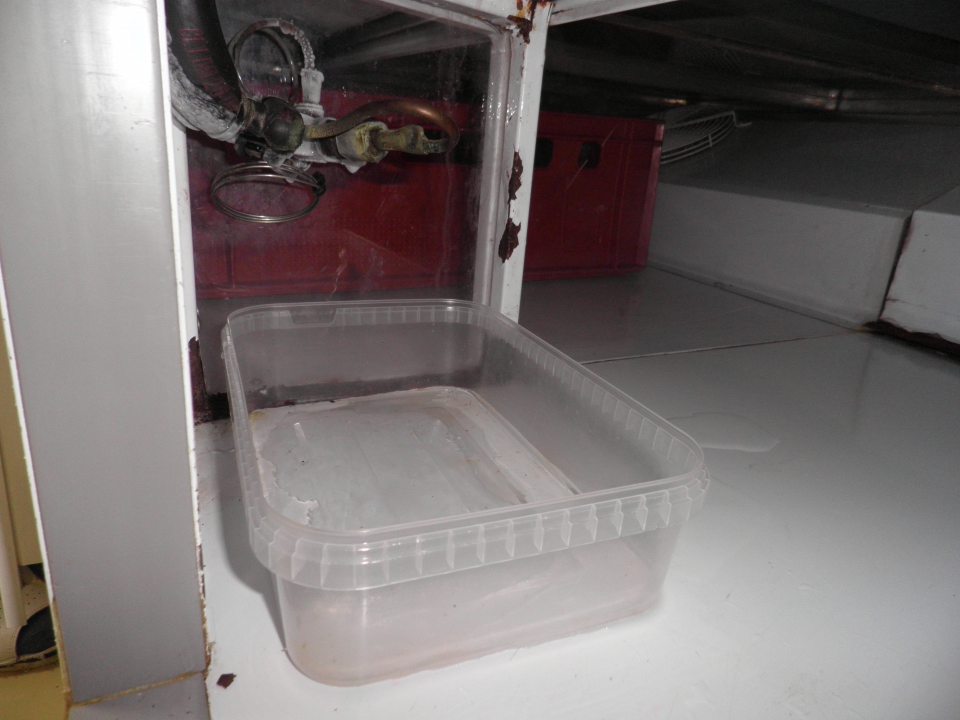 V chladiacom zariadení pultového predaja kondenzát zachytávaný do otvorenej plastovej nádoby, v zadnej časti korózia