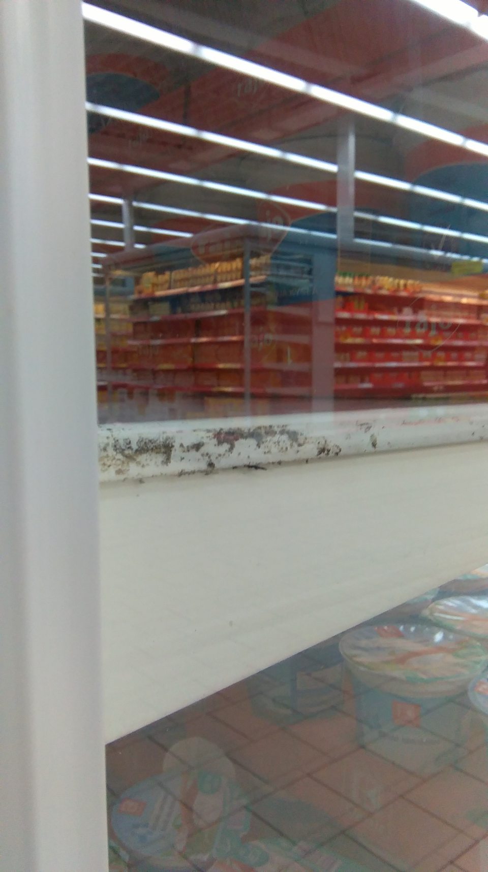 Chladiaca vitrína s mliečnymi výrobkami - znečistená úložná plocha a bočná stena chladiacej vitríny