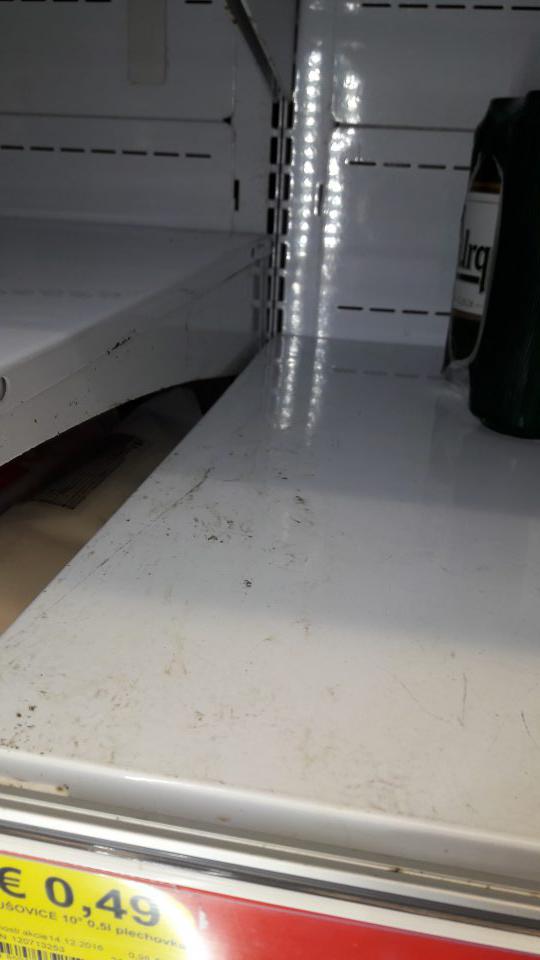 V predajni v chladiacej vitríne s pivom znečistená úložná plocha.