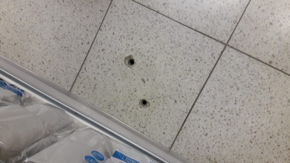 Na predajnej ploche v blízkosti vstupu do skladových priestorov - porušená celistvosť podlahy.