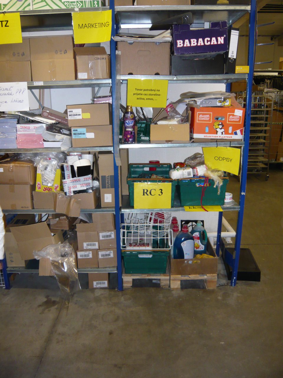 Obalový materiál skladovaný v krabiciach nehygienickým spôsobom. V tesnej blízkosti je uskladnený drogistický tovar, vyradený tovar a nepotrebné veci.