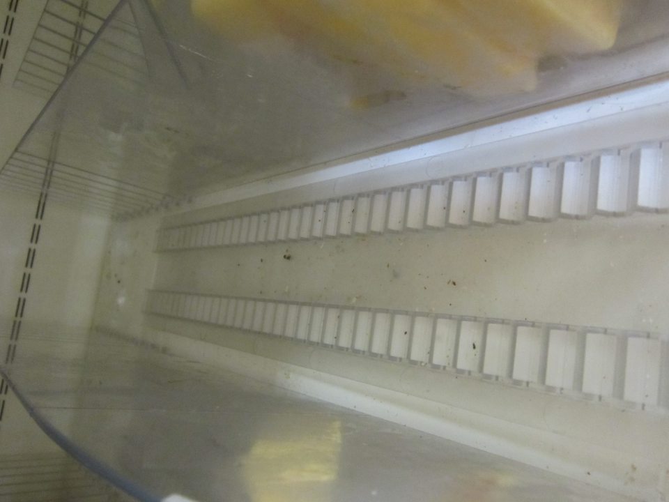 Na predajnej ploche s balenými krájanými syrmi znečistená chladiarenská vitrína. 