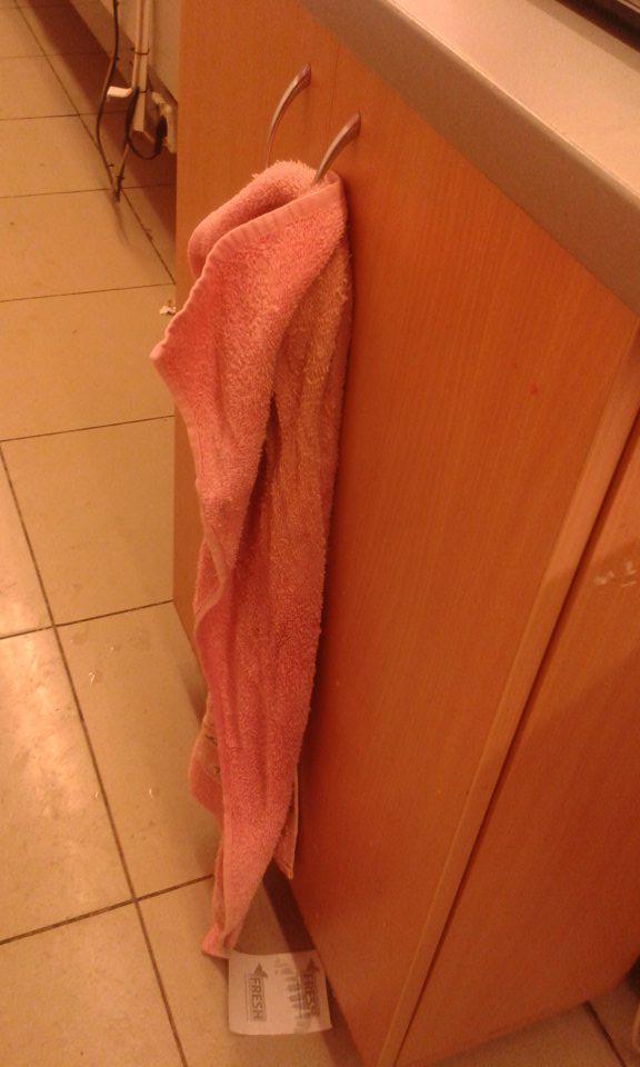 Na osušenie rúk pri predaji mäsových výrobkov z pultu sa požíva znečistený froté uterák, prevesený cez madlo skrinky.