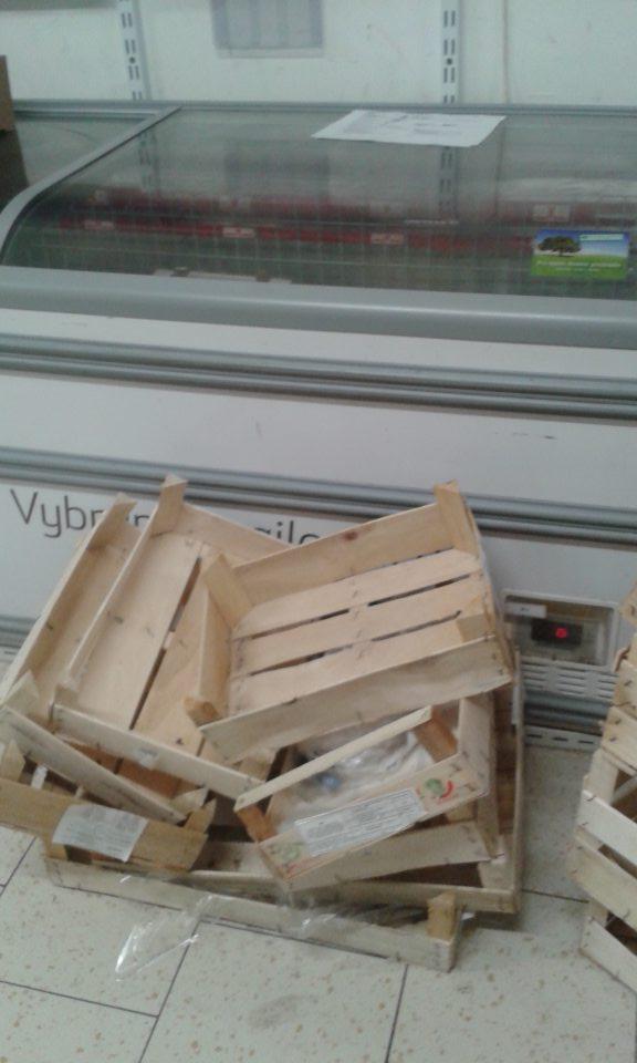 V zázemí prevádzky nevratné obaly, drevené bedničky umiestnené vedľa chladiaceho boxu.