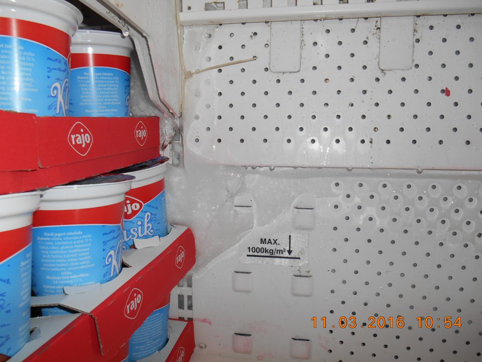 Chladiaca vitrína na uchovávanie jogurtov na predajnej ploche -  hrubá vrstva namrznutého kondenzu, zasahujúceho aj na kartóny s uchovávanými jogurtami.