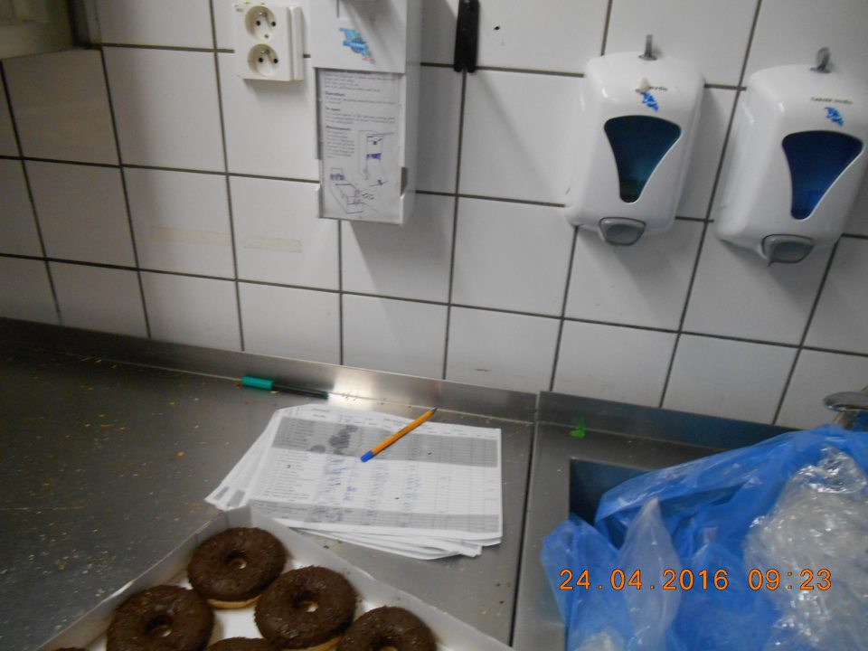 Nádoba s dezinfekčným prostriedkom na dezinfekciu rúk umiestnená priamo nad stolom, kde sa rozmrazujú pekárske výrobky určené na priamy konzum.