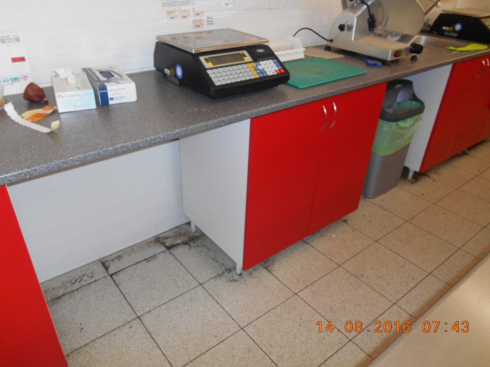 V predajni za chladiacim pultom s mäsovými výrobkami znečistená podlaha.