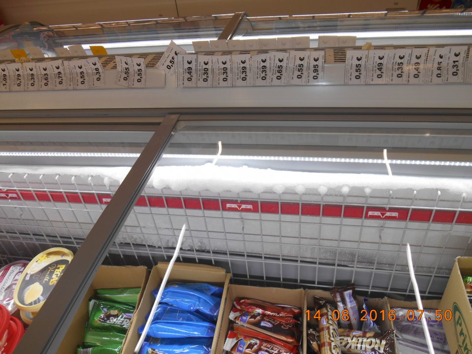 Na predajnej ploche zvýšená námraza na stenách mraziaceho boxu s mrazenými nanukmi a krémami.