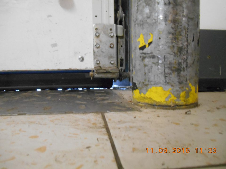 Na rampe príjmu tovaru poškodená, netesniaca rolovacia brána.