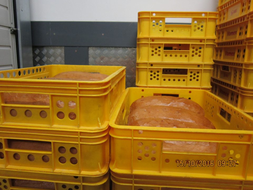 V príjmovej časti skladu v prepravkách skladovaný nebalený chlieb, ktorý nie je prikrytý a chránený pred kontamináciou z prostredia.