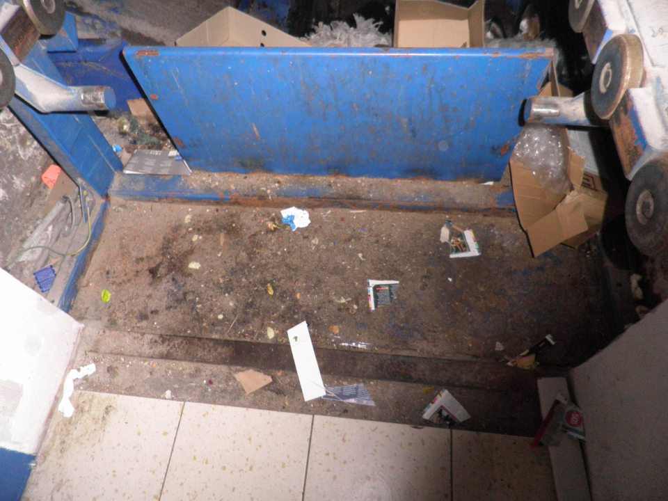 V prevádzke znečistená podlaha v okolí lisu na kartóny.