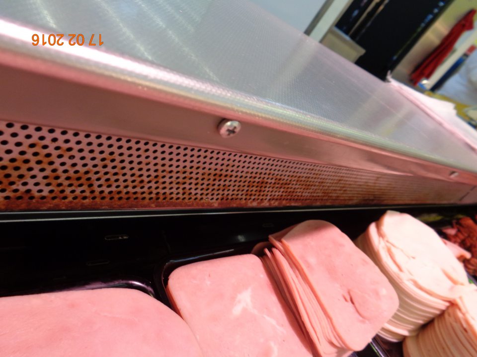 Hrdzavé nerezové lišty v chladiacich vitrínach určených na vystavovanie nebalených mäsových a mliečnych výrobkov a šalátov.