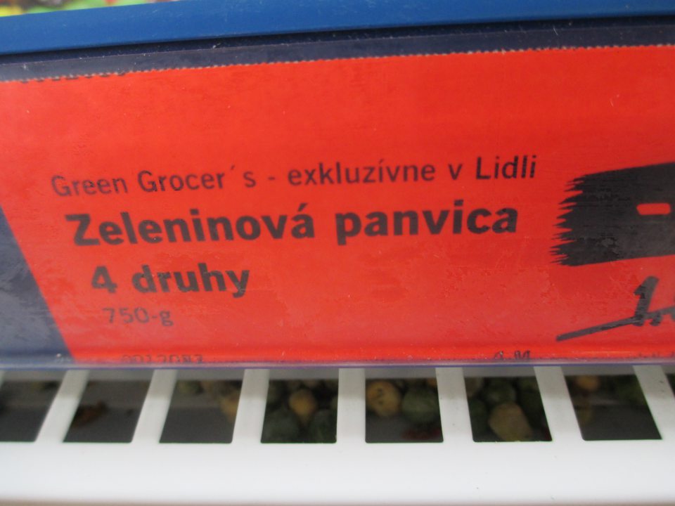 Znečistený priestor pod kovovou mriežkou na mraziacej vitríne s mrazenou zeleninou.
