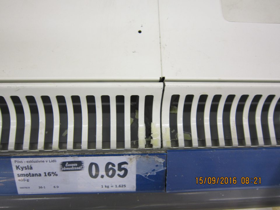 Na predajnej ploche v chladiacej vitríne znečistený priestor pod mriežkami zvyškami potravín. 