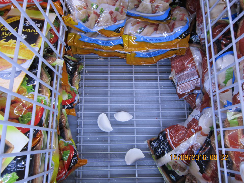 Na predajnej ploche na dne mraziaceho boxu rozsypané pirohy a úlomky z potravín. 