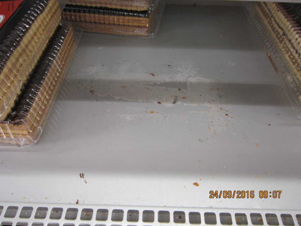 Na predajnej ploche v chladiacej vitríne na polici zaschnutá škvrna s nečistotami.