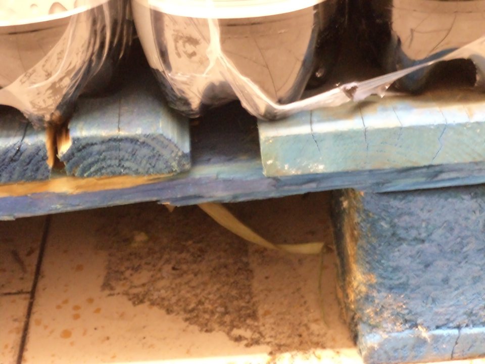 Znečistená podlaha pod paletami