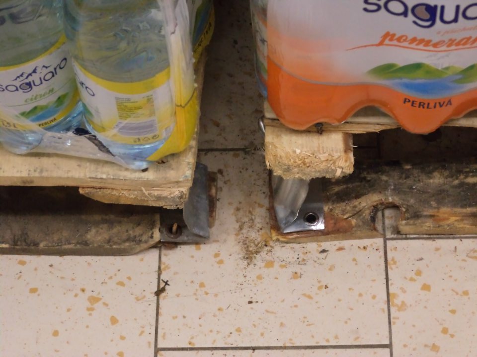  Znečistená podlaha  medzi paletami s nealkoholickými nápojmi