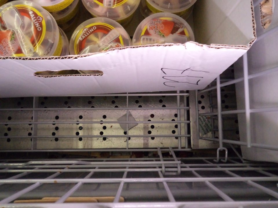 Popadané bobuľové ovocie na dne mraziaceho boxu s mrazenými krémami