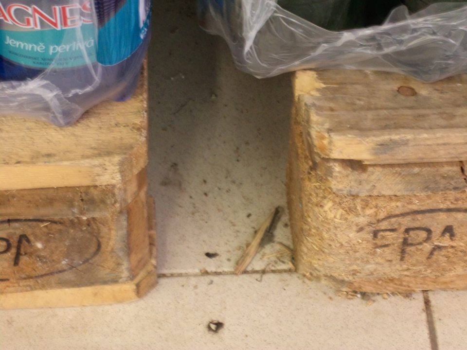 V predajni pod paletami s minerálnymi vodami znečistená podlaha.