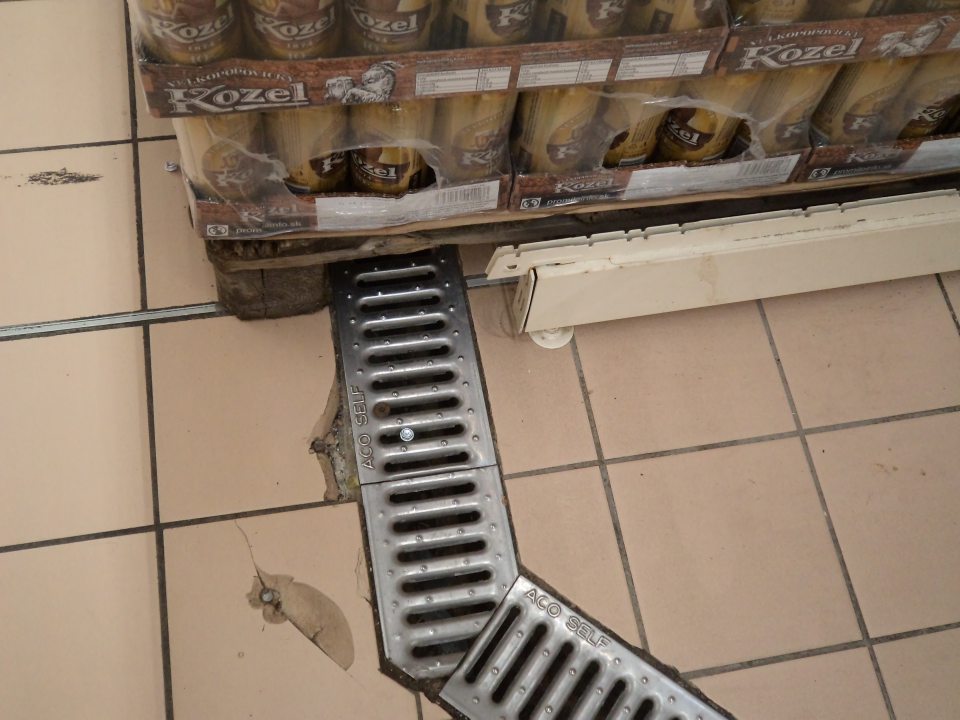 Poškodená dlaždica pri palete s pivami " Kozel" na predajnej ploche