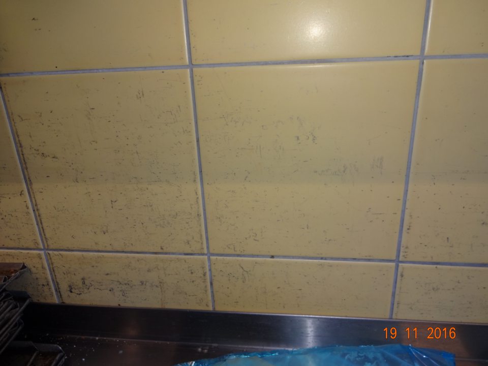 Znečistený obklad steny za pracovným stolom v manipulačnom priestore pekárne. 