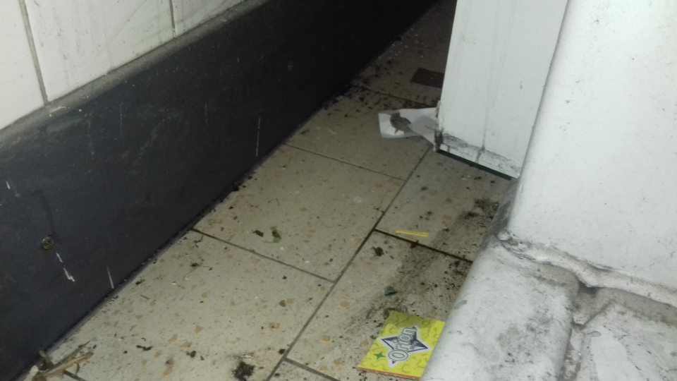 Znečistená podlaha za lisom na kartónové obaly v sklade potravín