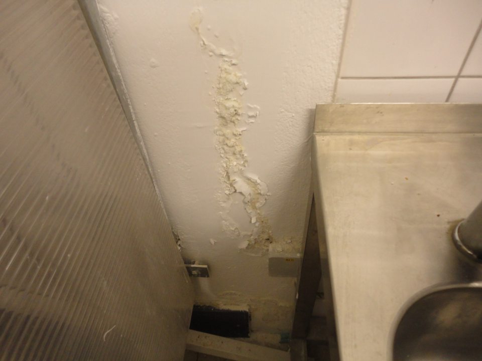 Poškodená omietka steny pri umývadle v prípavovni oddelenia dopeku