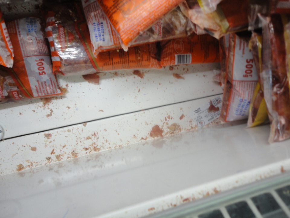 Znečistené dno mraziaceho zariadenia s kuracími pečienkami v predajni