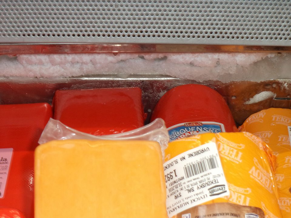 Vrstva námrazy na výparníku chladiacej vane s originálne balenými syrmi 