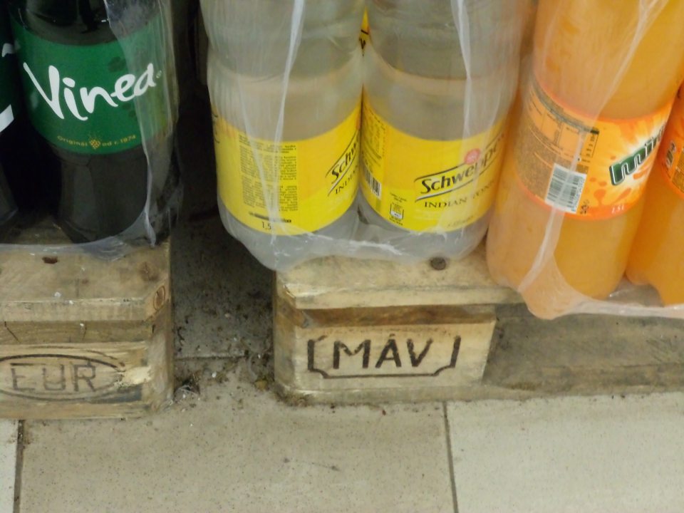 Znečistená,zaprášená podlaha medzi paletami s nealkoholickými nápojmi v predajni 