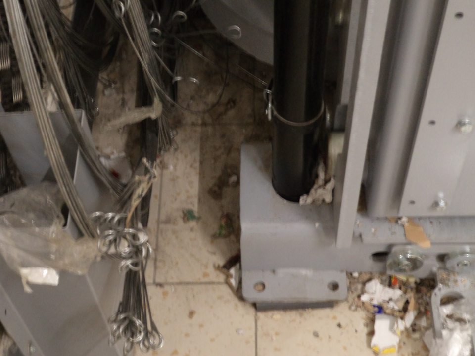 Znečistená podlaha okolo lisu na papierový odpad v sklade potravín