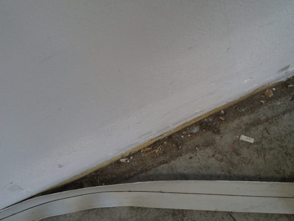 Odlepená podlahová lišta a znečistená podlaha pod odlepenou časťou na príjme suchých potravín