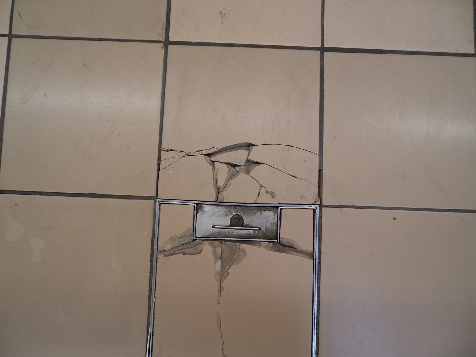 Poškodená dlažba pred chladiacim regálom s čerstvým chladeným mäsom