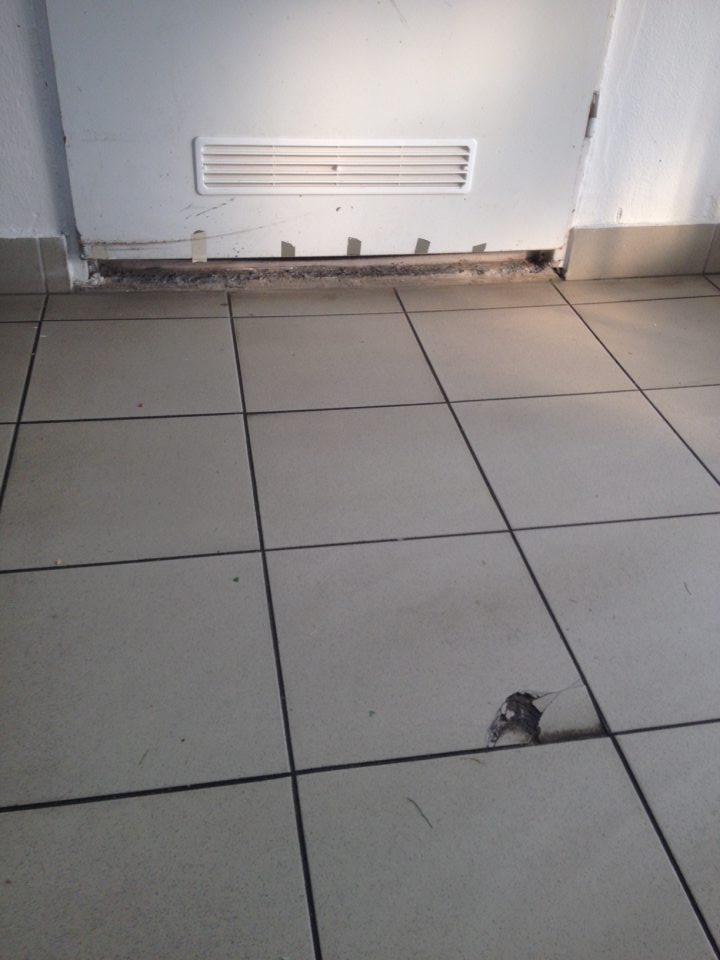 Poškodený prah dverí v sklade potravín, poškodená podlaha.