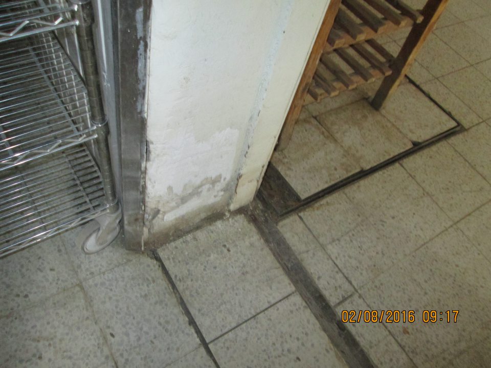 V prevádzke na prechodových dverách z časti balenia finálnych výrobkov do časti uskladnenia finálnych výrobkov je poškodená omietka steny s opadávajúcou omietkou. 