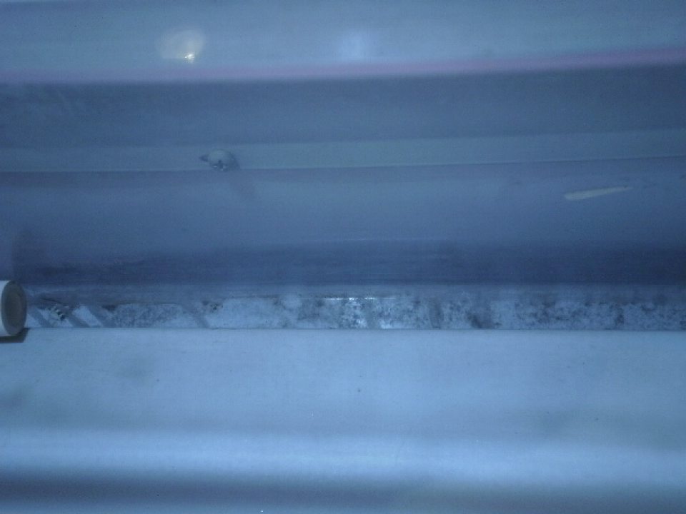 Na predajnej ploche znečistený vnútorný okraj chladiacej vane s mliečnymi výrobkami.