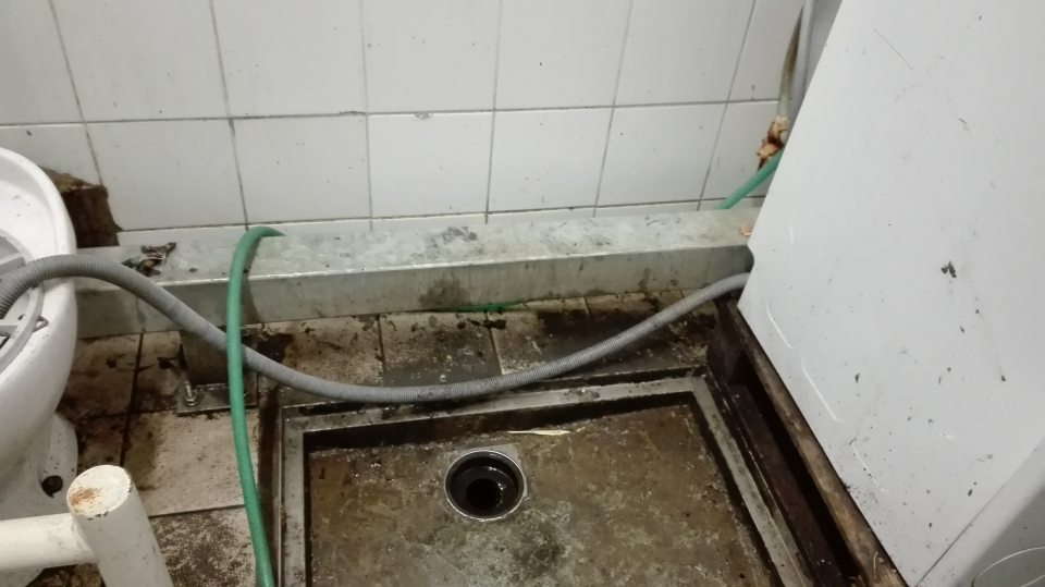 V upratovacej miestnosti prevádzky znečistená výlevka, podlaha a obklad steny.