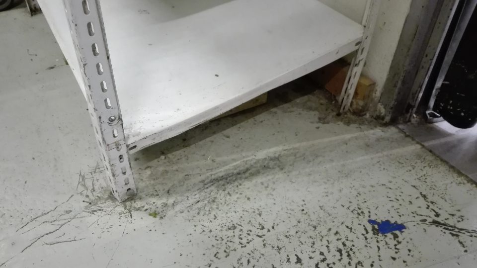V manipulačnej chodbe skladu poškodený regál a znečistená podlaha.