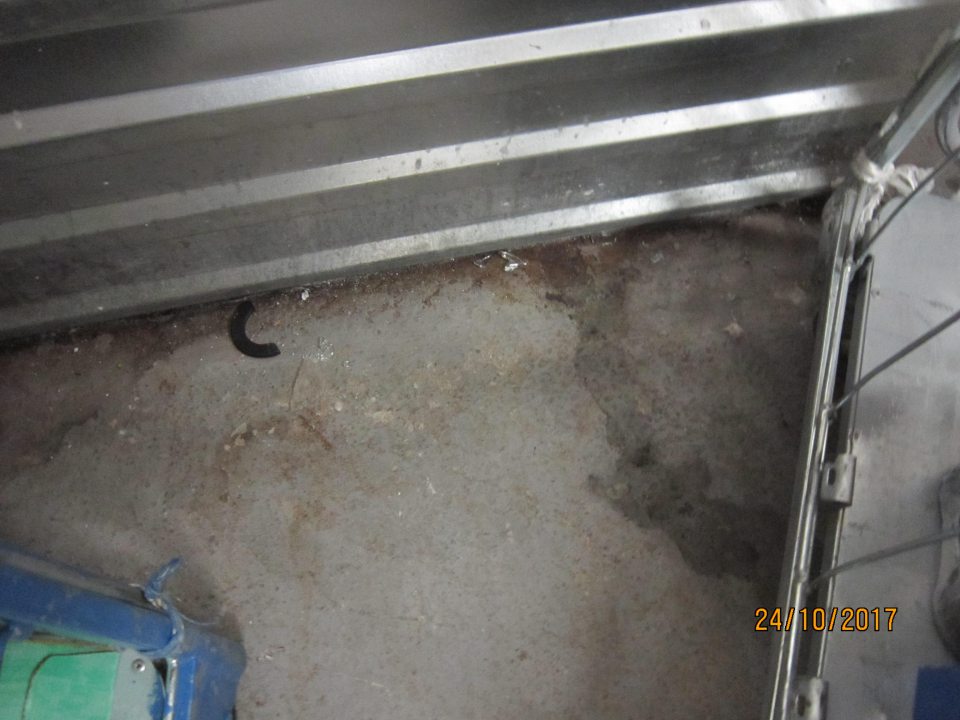 V zázemí prevádzkarne znečistená podlaha.  