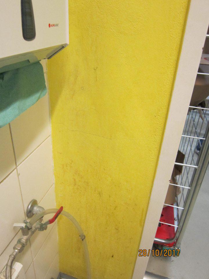 V šatni zamestnancov znečistená stena. 