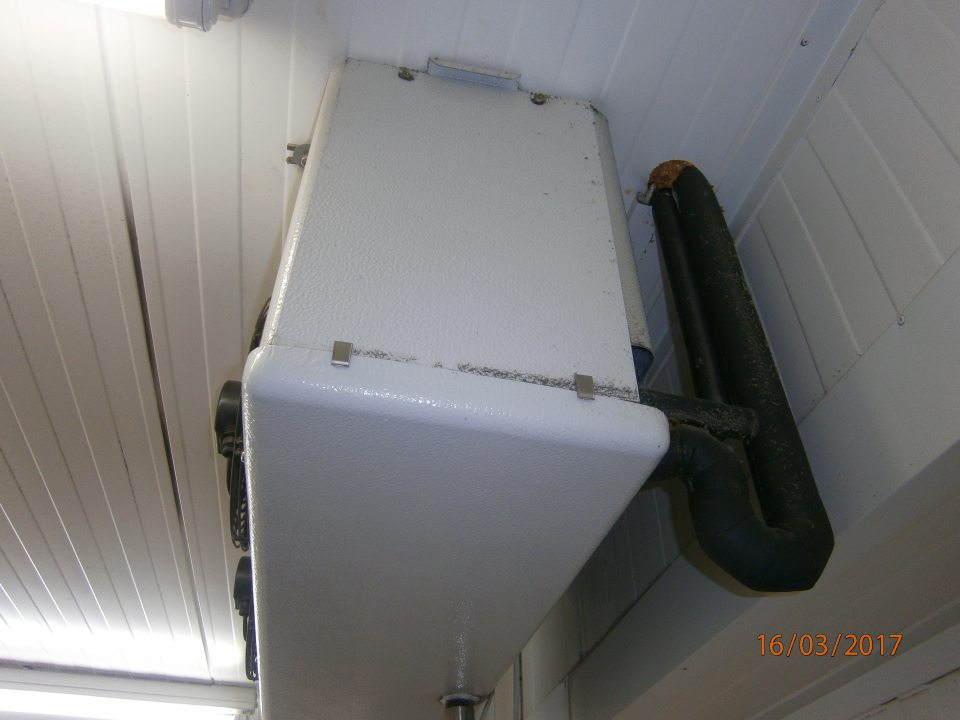 V chladiarni mliečnych výrobkov zaprášené mriežky ventilátorov chladiacej jednotky, priľahlé potrubie a strop .