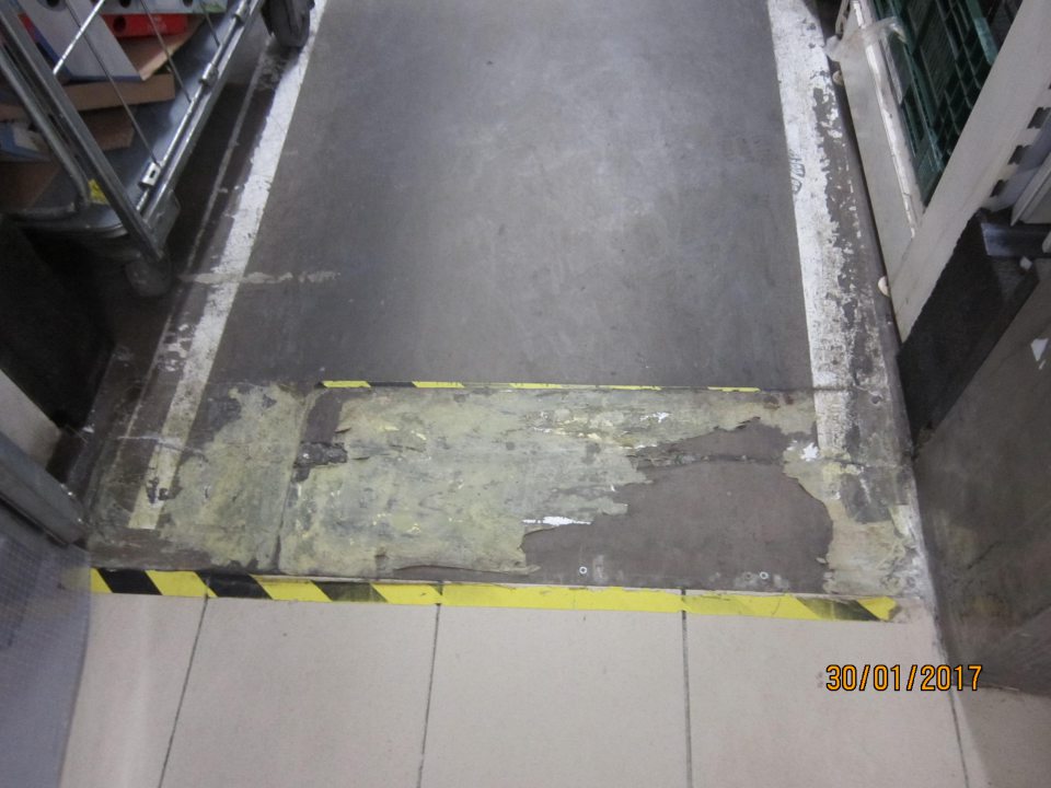 Pri vstupe do zázemia prevádzkarne poškodená podlaha.